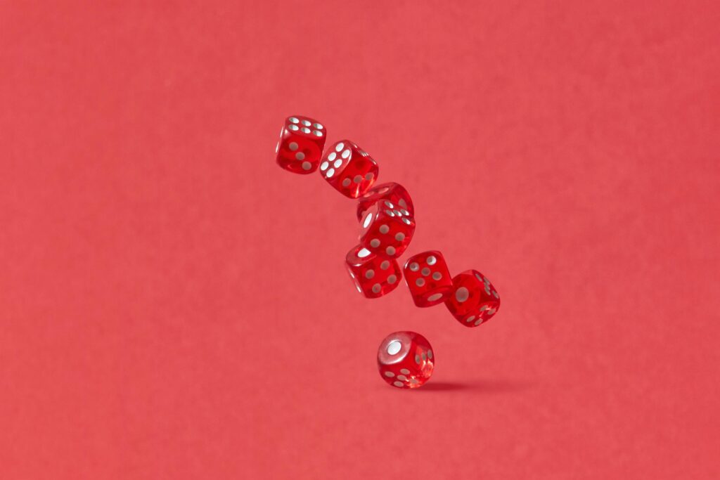 Dynamic shot of red dice tumbling mid-air against a crimson backdrop, perfect for gaming themes.